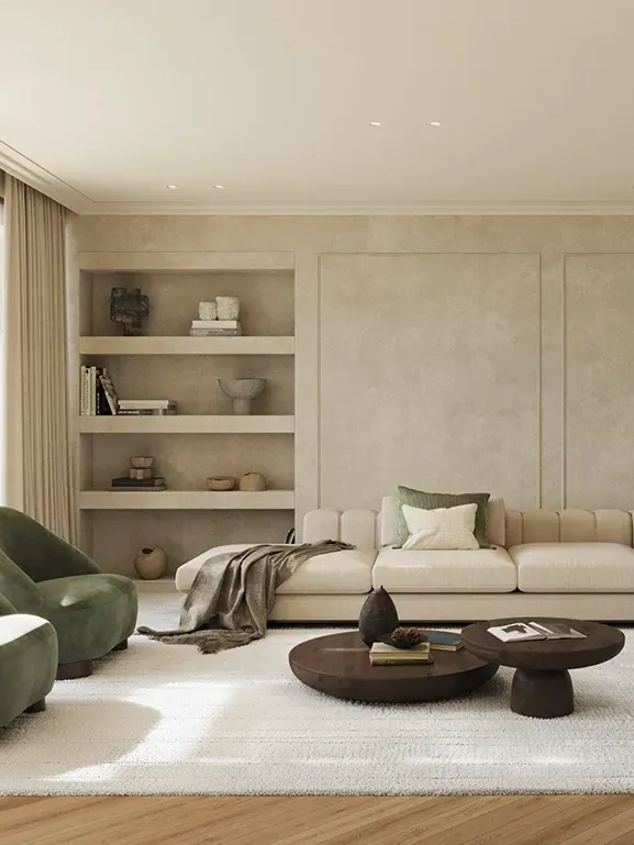 Refined living room with a modular cream sofa, green velvet armchairs and built-in shelves, styled with organic textures and soft natural light.