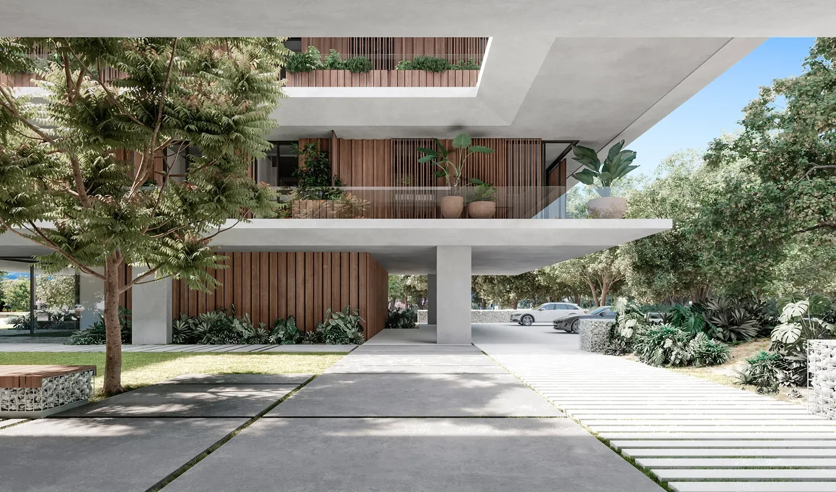 Open-air ground level of a luxury residence by LUV Studio, featuring minimalist concrete structure, wood paneling, and lush landscaping.