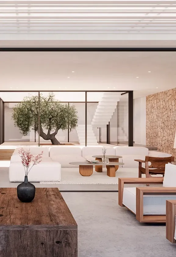 Terrace view into a modern living space with dining area and indoor olive tree, designed with stone walls, wood tones, and soft neutral colors.