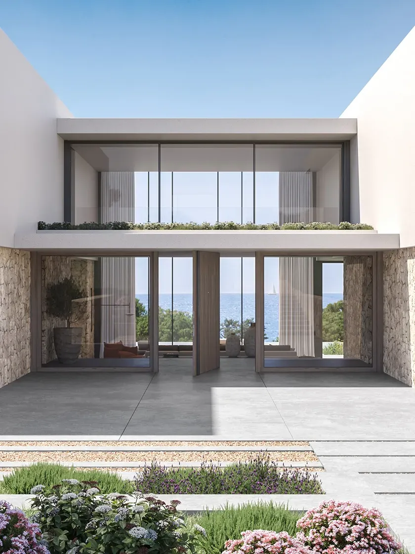 Detail of the villa’s entrance showcasing symmetrical glass doors, sleek facade lines, and ocean view beyond.