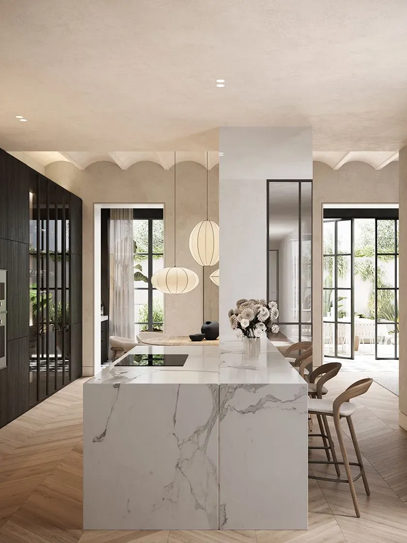 Elegant luxury kitchen with marble island, integrated lighting, and seamless connection to a bright outdoor patio.