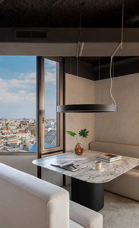 Private corner meeting space with panoramic city views and marble table at LUV Studio's Urquinaona Office