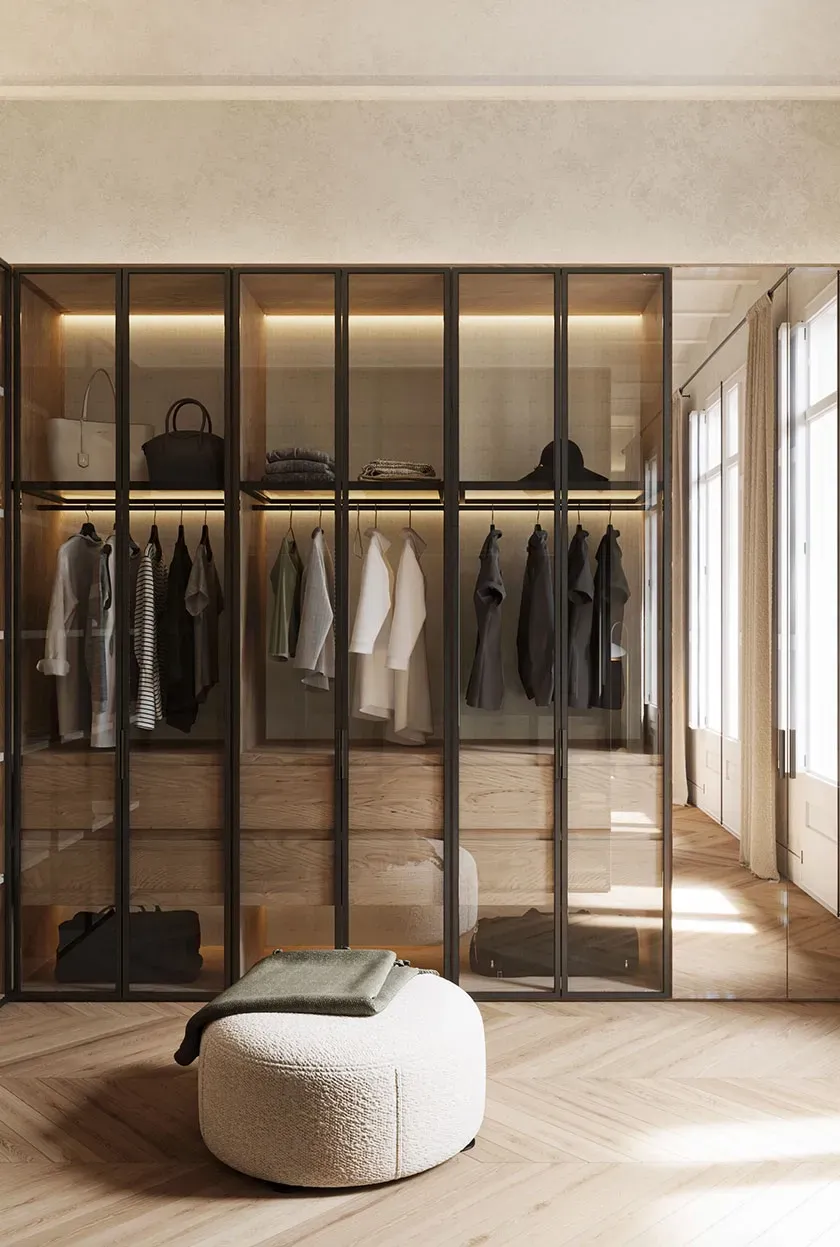 Minimalist walk-in closet with glass doors, wooden finishes, and ample natural light for a luxurious dressing space.