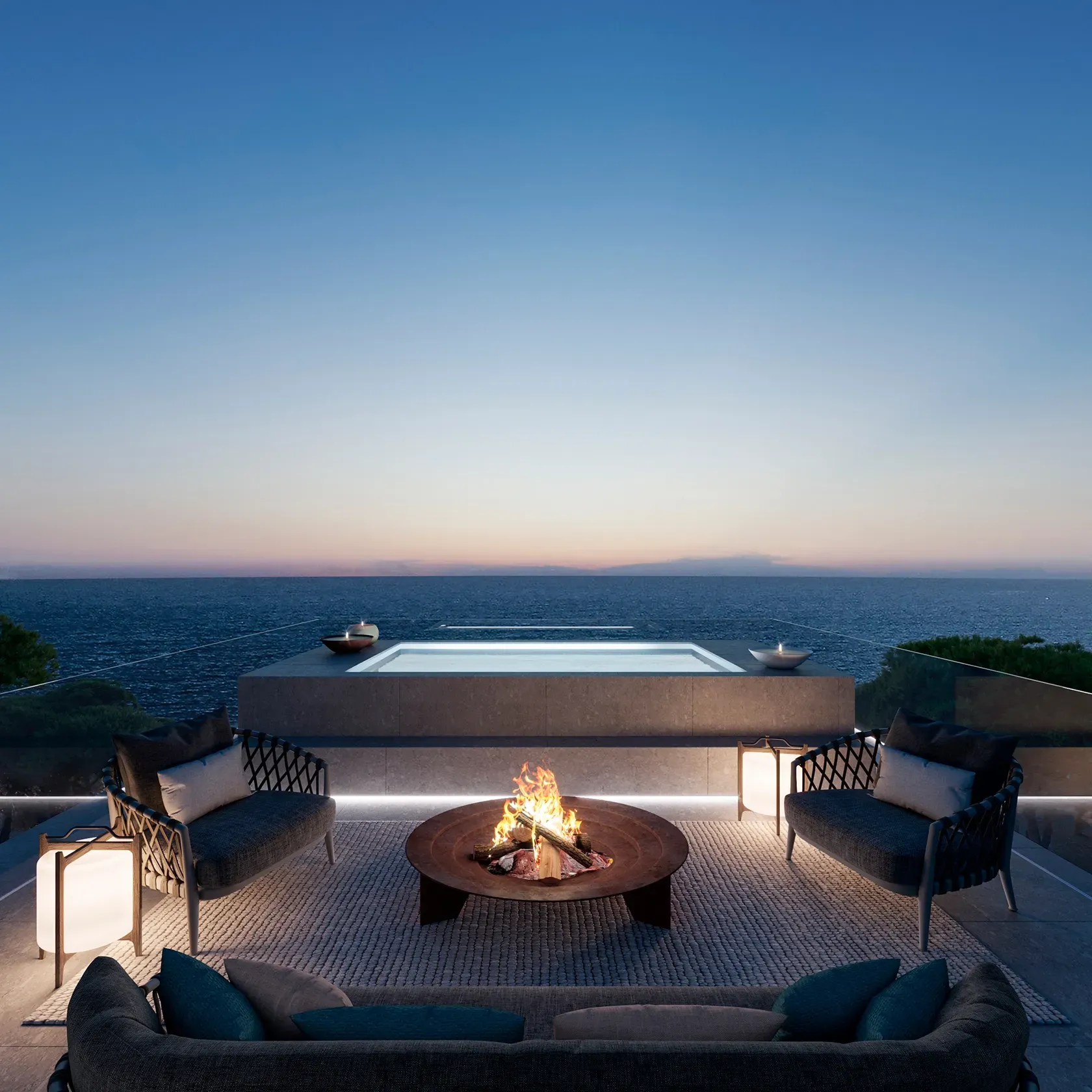 Rooftop terrace with jacuzzi and firepit overlooking the sea at sunset.
