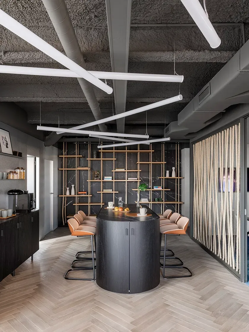 Contemporary office kitchen with tall bar table, wood finishes and minimalist shelving at LUV Studio