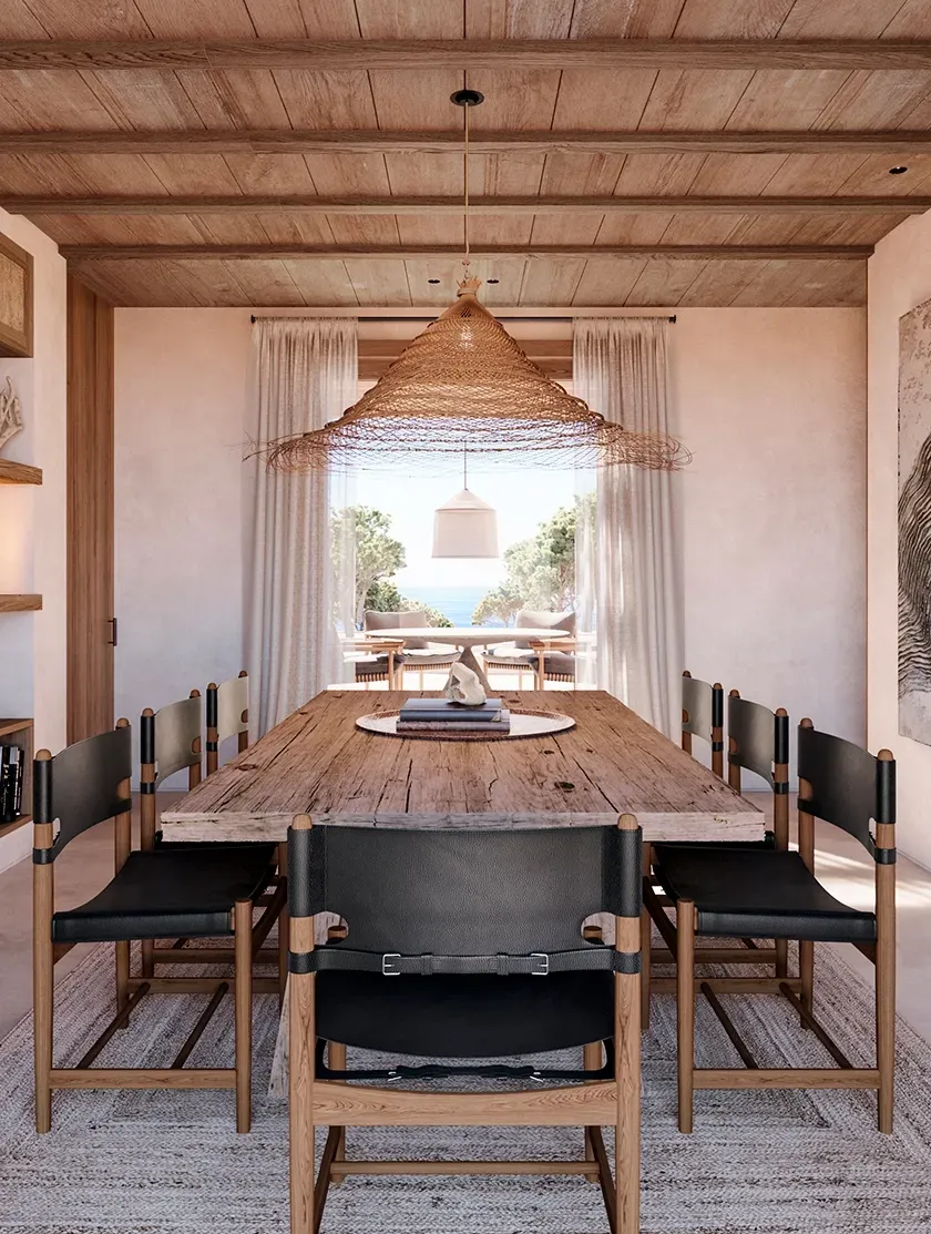 Rustic dining space with a raw wooden table, black leather chairs, and sea views, created by LUV Studio.