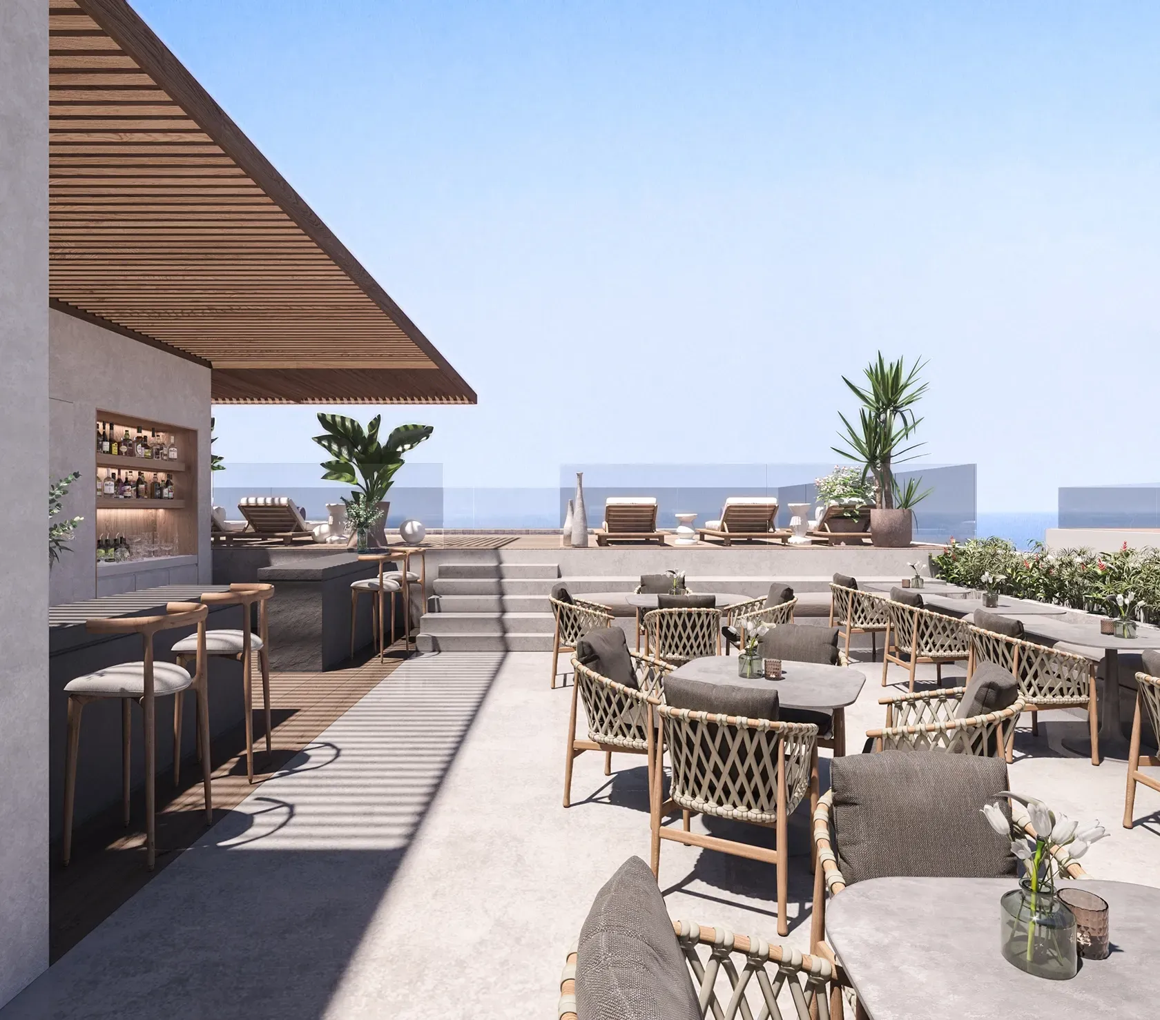 Rooftop lounge and bar with ocean view, sunbeds and outdoor dining area at Carlyle