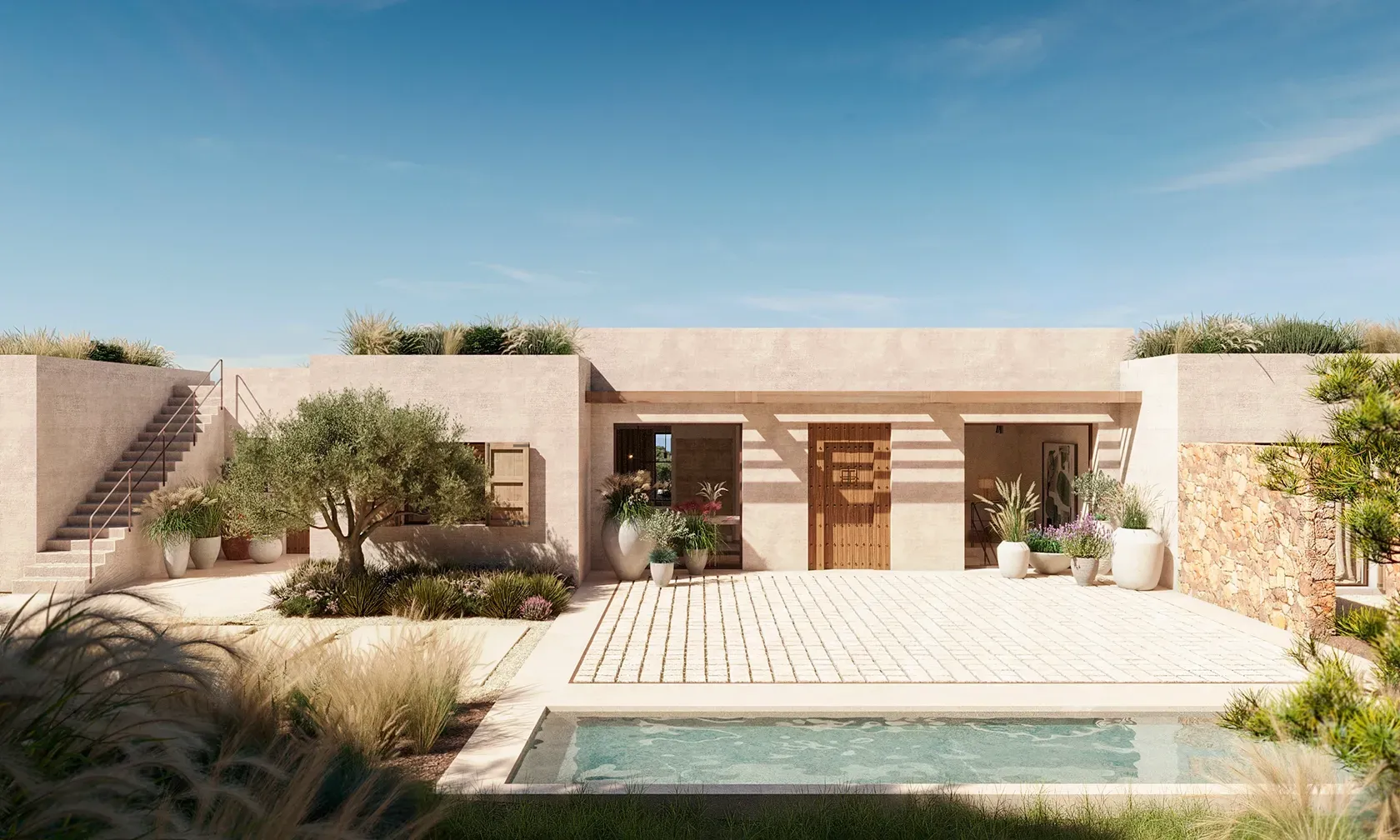 Minimalist villa exterior with natural stone and desert landscaping surrounding a serene plunge pool.