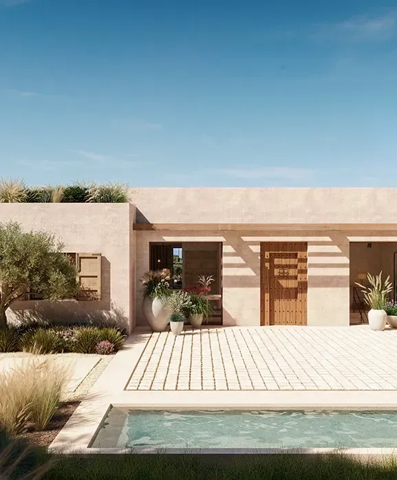 Minimalist villa exterior with natural stone and desert landscaping surrounding a serene plunge pool.