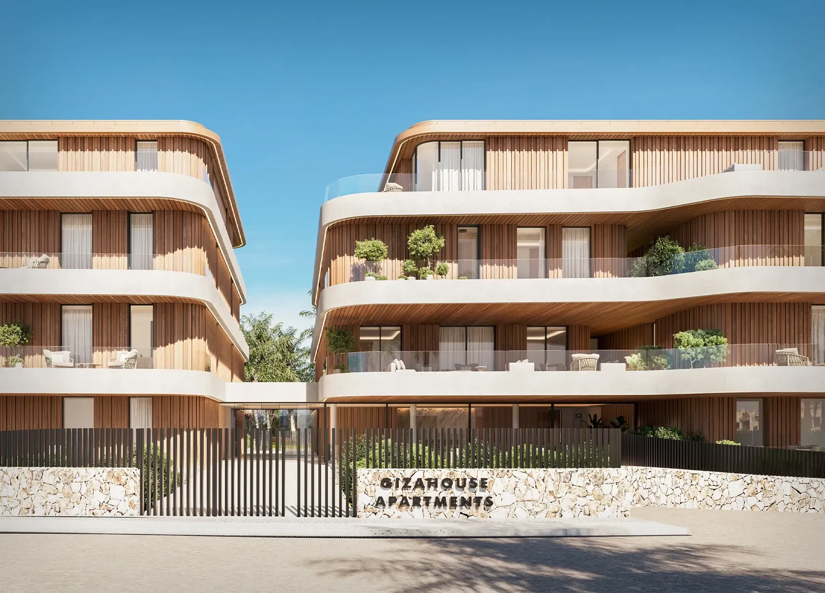 Street view of GiaHouse Apartments’ gated entrance with stone and metal detailing and curved façade by LUV Studio.