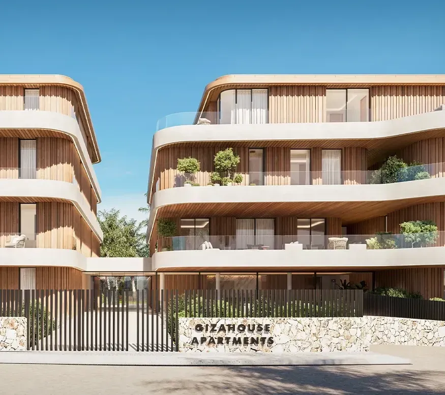 Street view of GiaHouse Apartments’ gated entrance with stone and metal detailing and curved façade by LUV Studio.