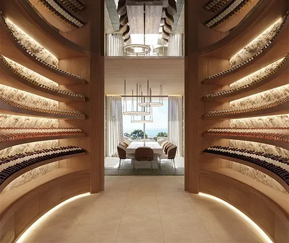 Curved wooden wine cellar with integrated lighting leading to a luxury dining room with sea views.