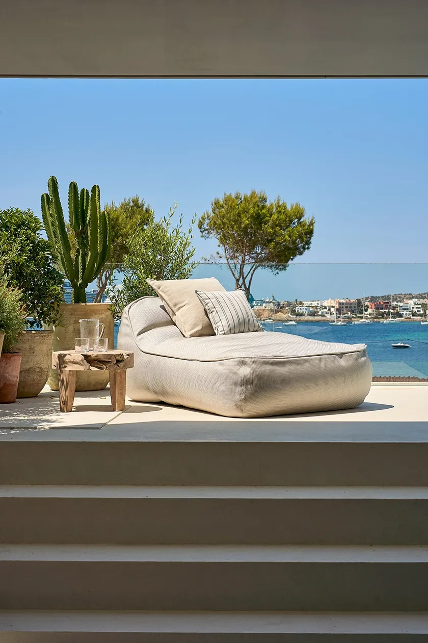 Outdoor terrace with lounge chair, cactus plants, and panoramic sea views over Ibiza port