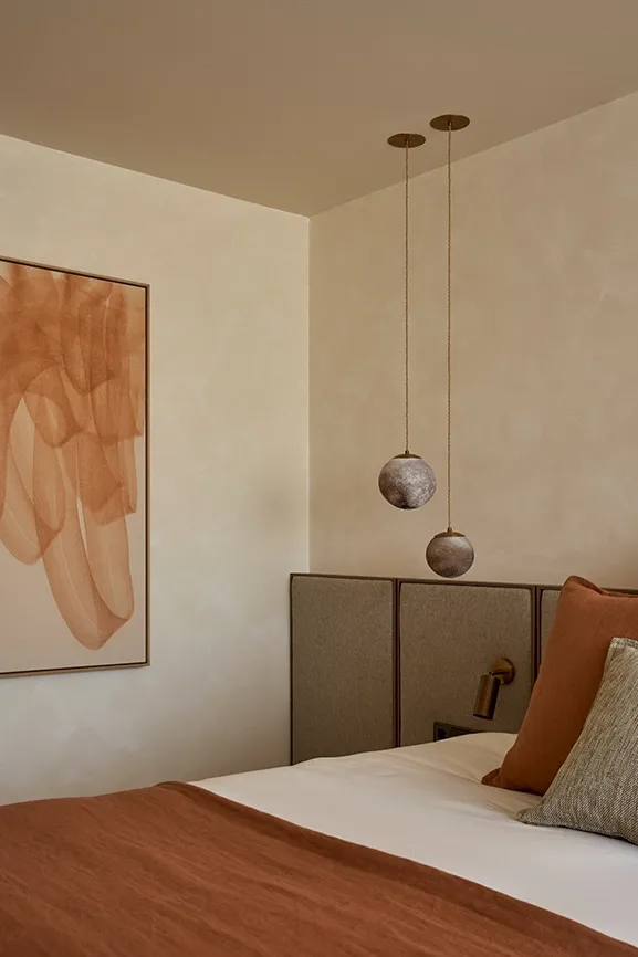 Master bedroom with earthy palette, linen bedding, and contemporary lighting for a serene Mediterranean atmosphere