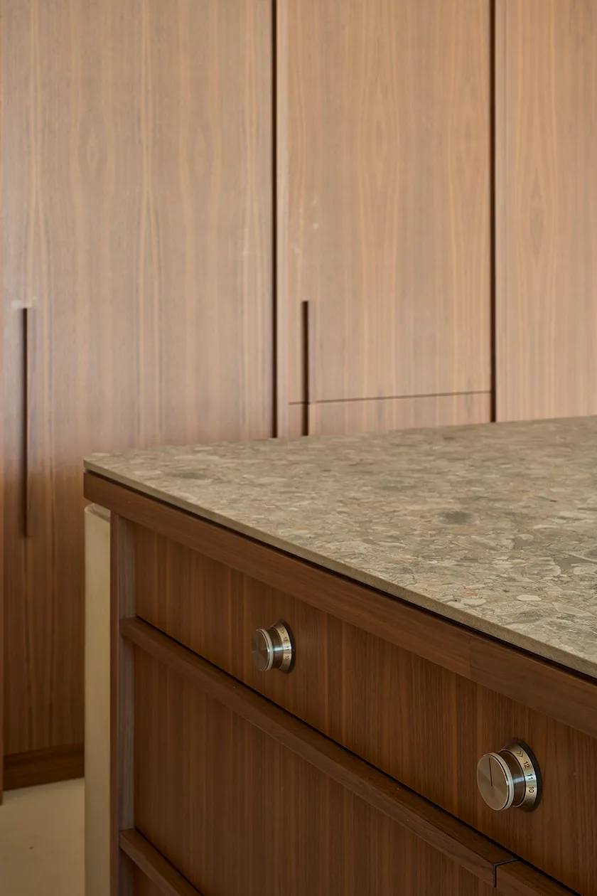 Detail of stone countertop and wood cabinetry in luxury Mediterranean kitchen