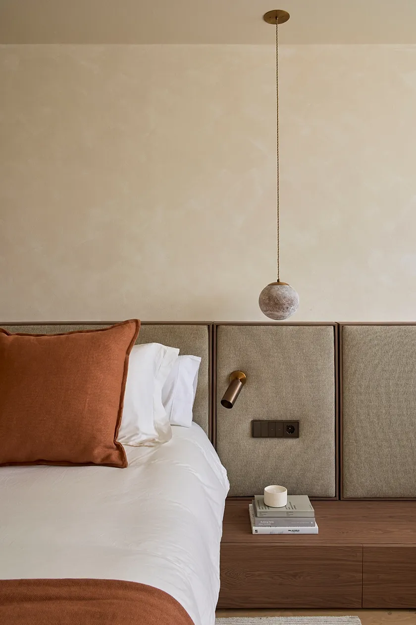 Master bedroom with earthy palette, linen bedding, and contemporary lighting for a serene Mediterranean atmosphere
