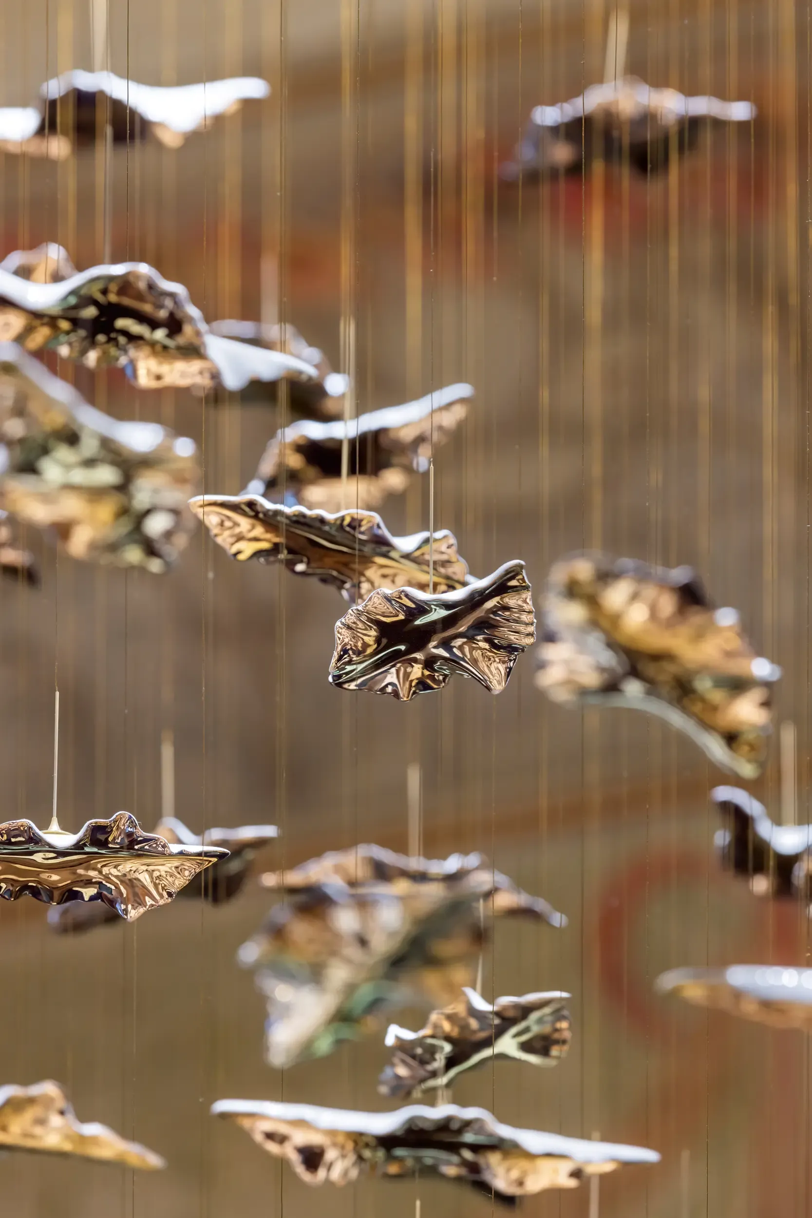 Macro detail of ceramic or metallic hanging pieces from contemporary chandelier in historic room.