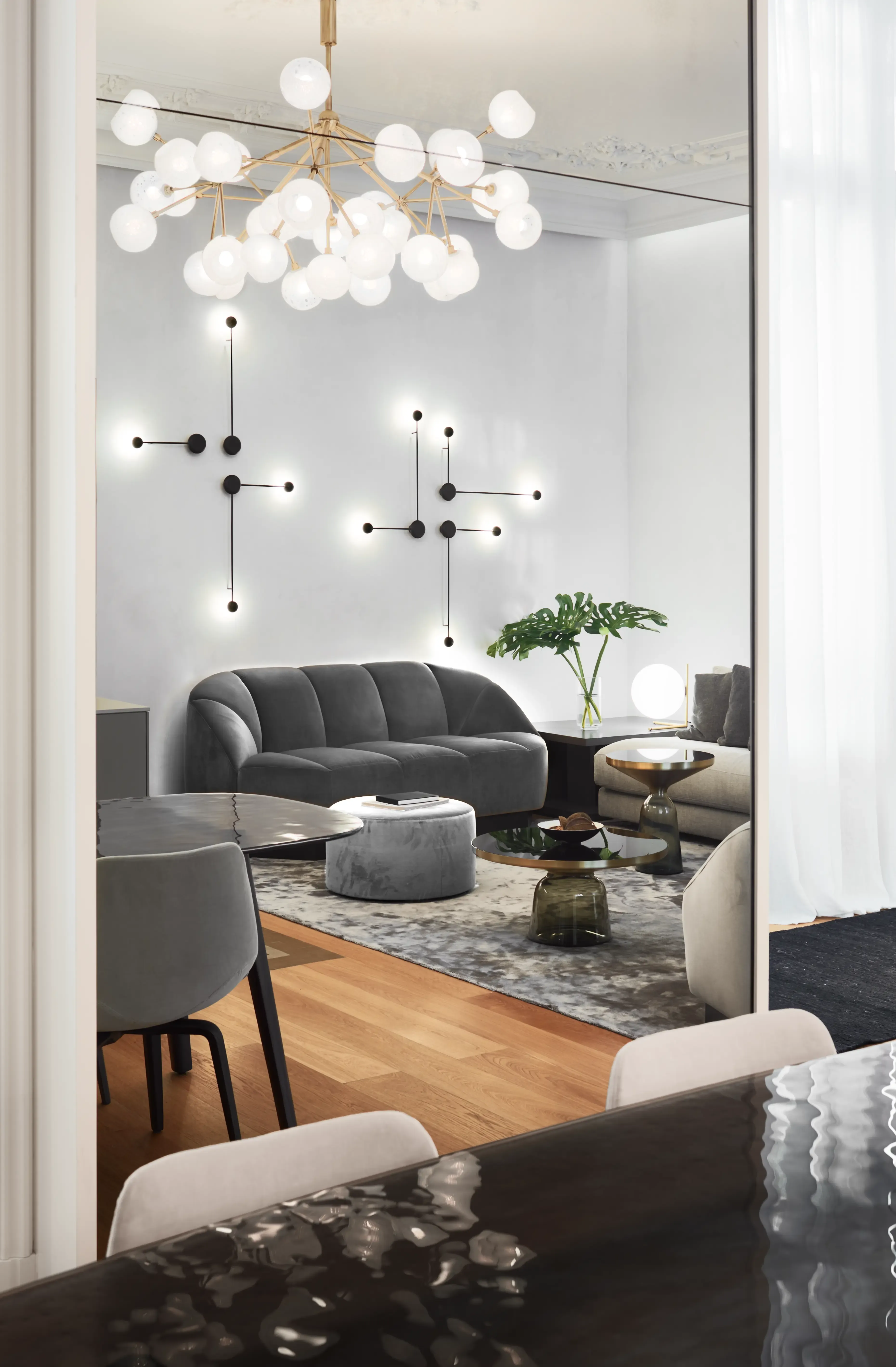 Sophisticated living room view with designer chandelier, plush sofas, and contemporary wall lighting, blending comfort with luxury apartment style.