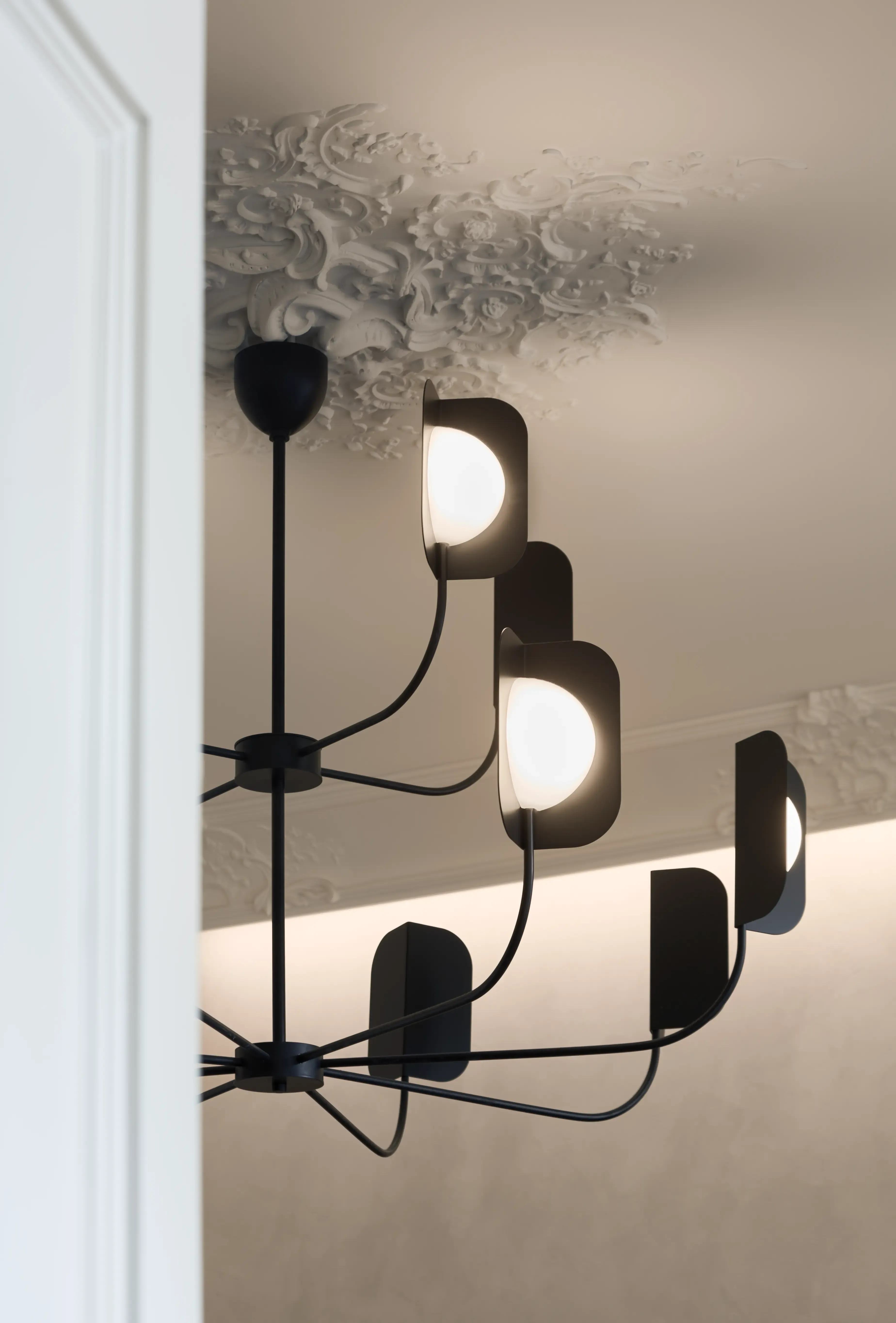 Artistic ceiling detail with ornate plaster molding and modern chandelier, combining classical craftsmanship with contemporary lighting design.