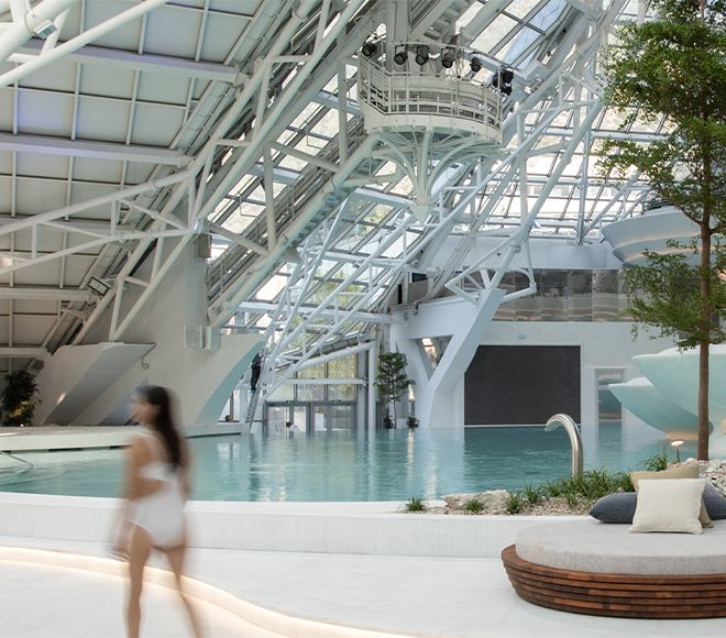 Modern wellness center interior with cascading water, curved architectural walls, and serene ambiance.