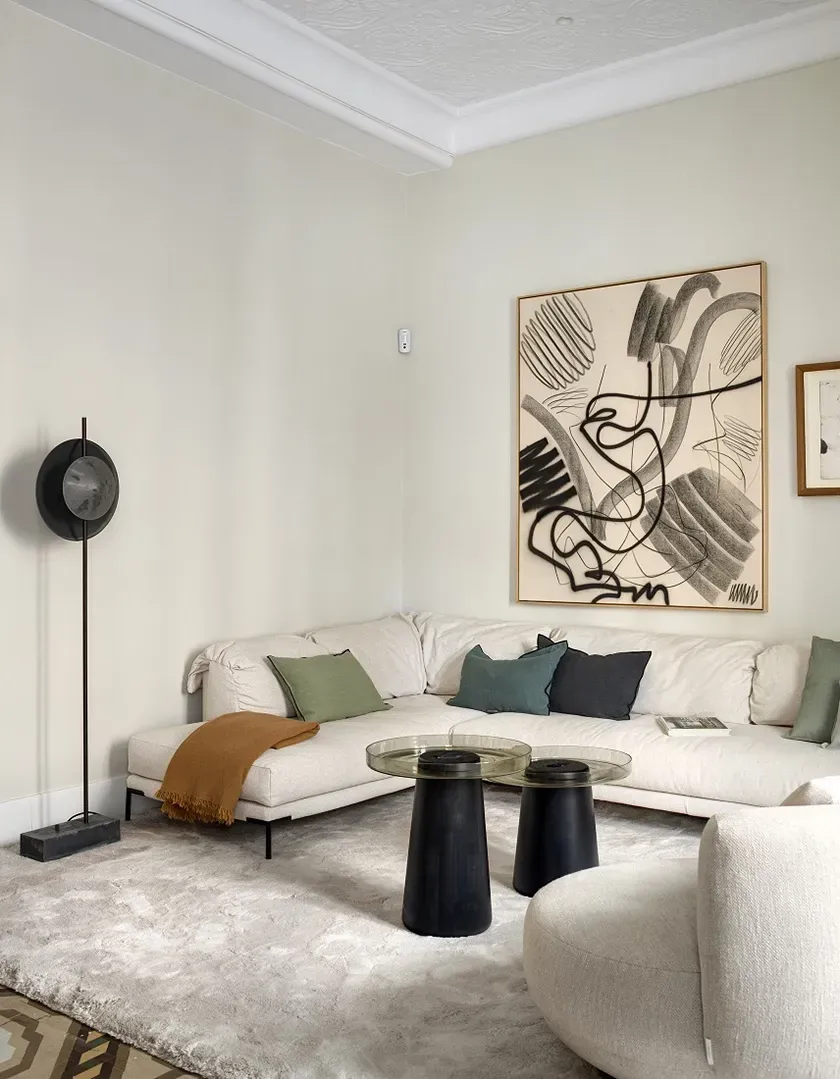 Contemporary living room in Casa Oller with cream sofa, graphic art and minimalist decor by LUV Studio.