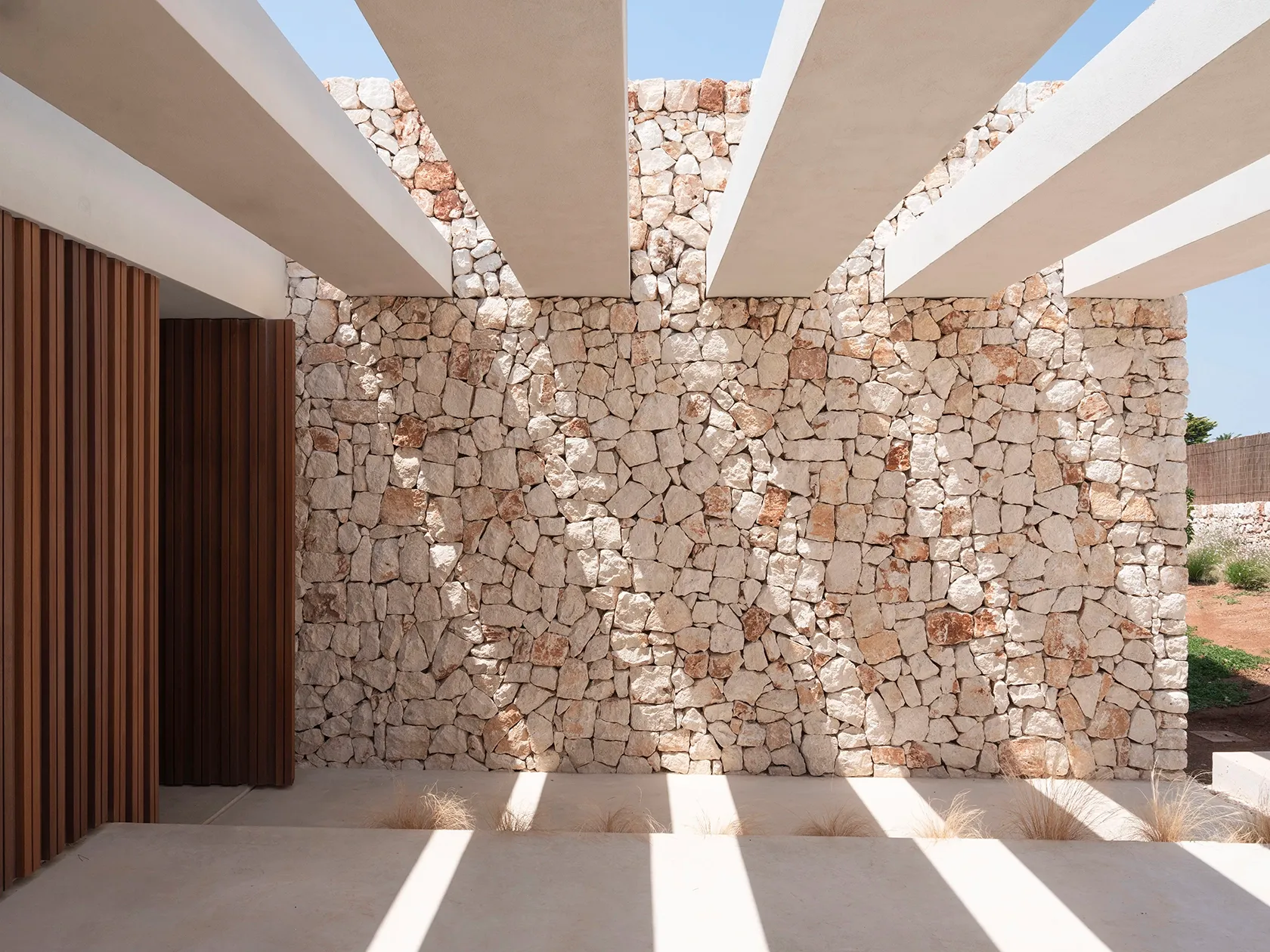 A pergola-topped entryway blending shade, texture, and warmth.