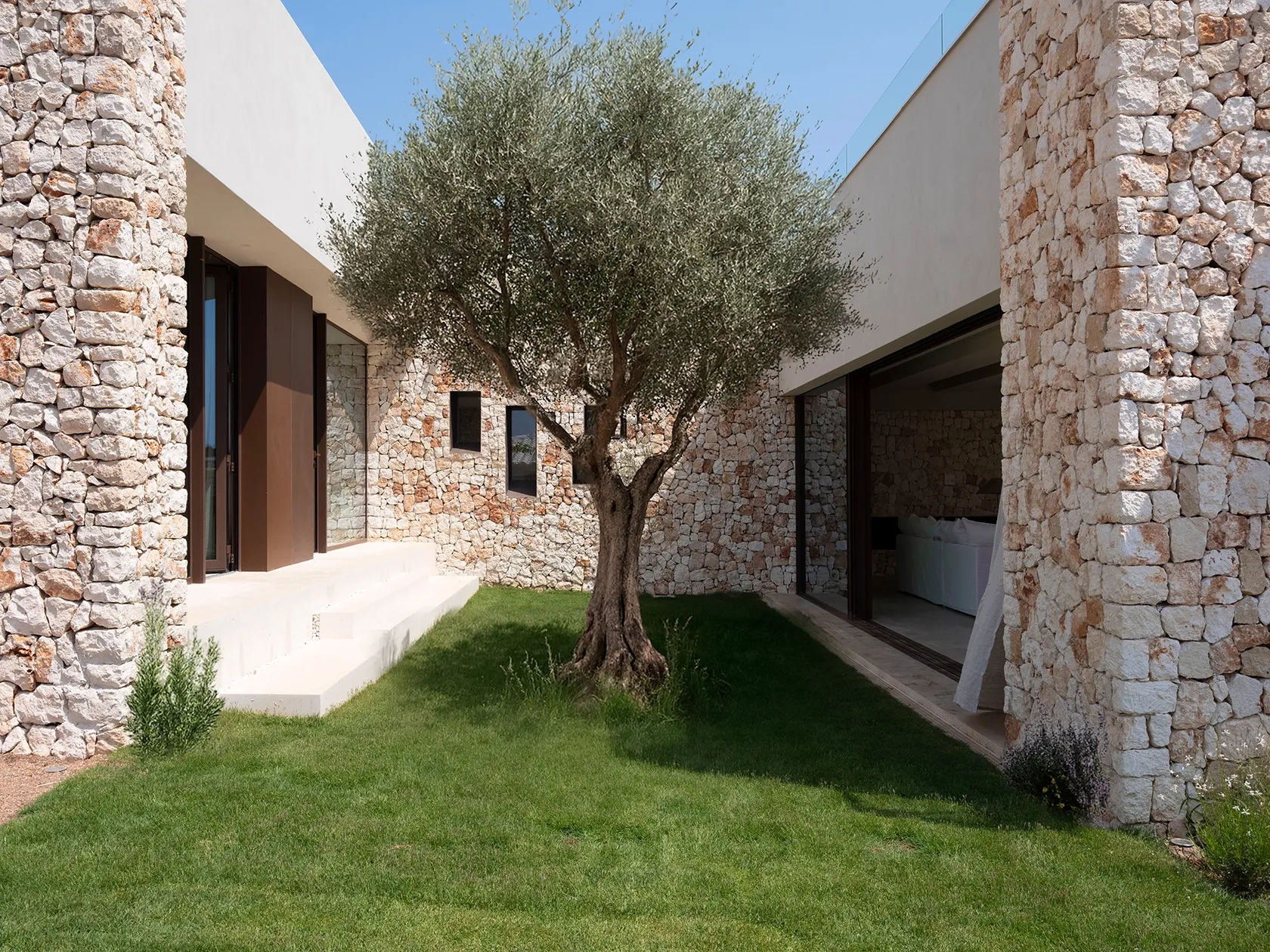 A quiet inner patio connecting interiors with the sky and nature.