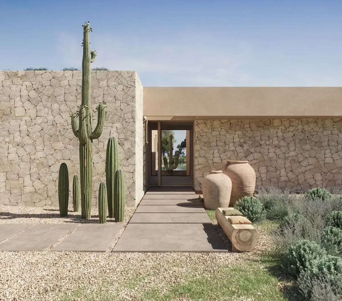 Exterior close-up of a luxury villa in Formentera, featuring cactus landscaping and stone-clad walls.