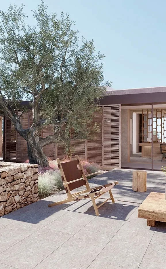 Tranquil courtyard with olive tree and wood furniture blending architecture and nature in LUV Studio Ibiza home.