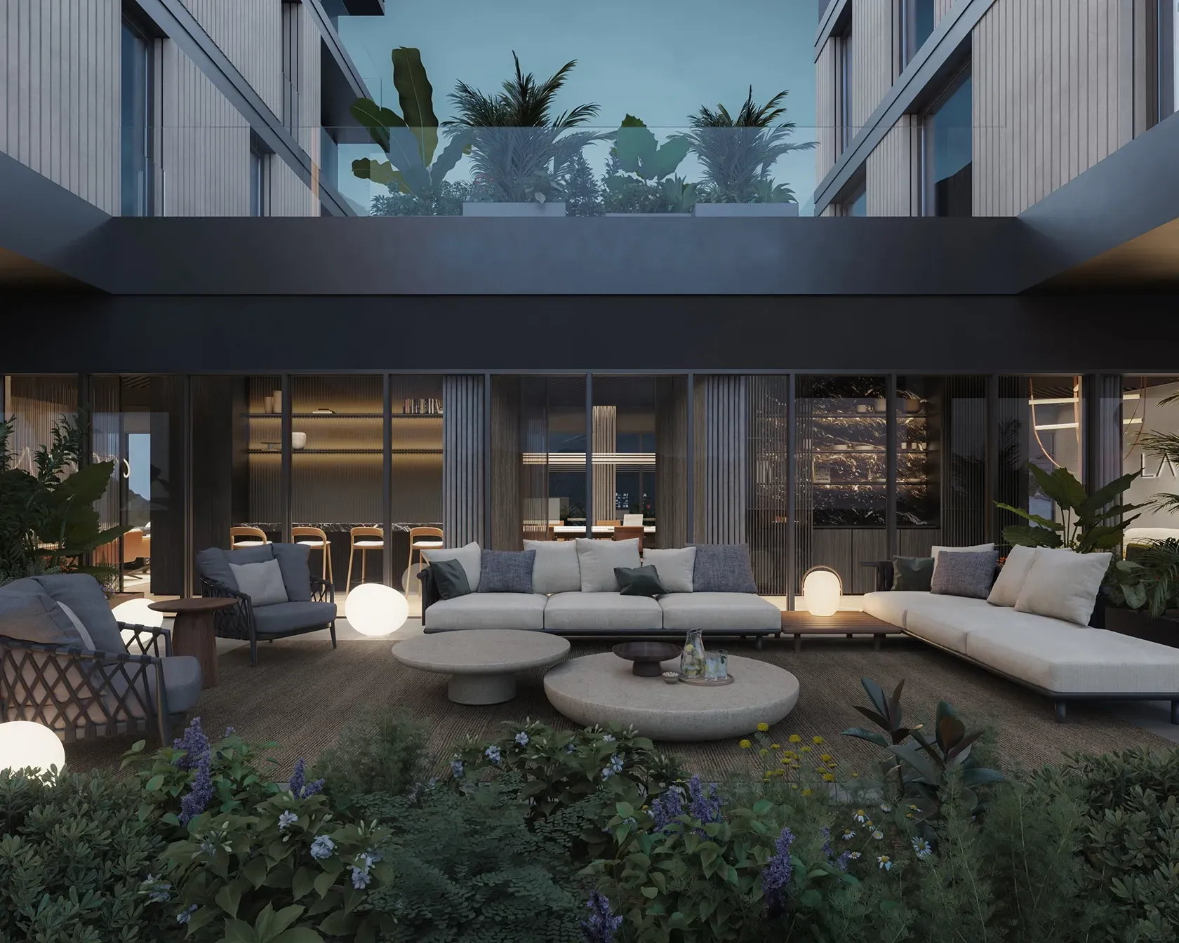 Evening view of outdoor lounge terrace surrounded by greenery at LUV Studio’s Andorra office.