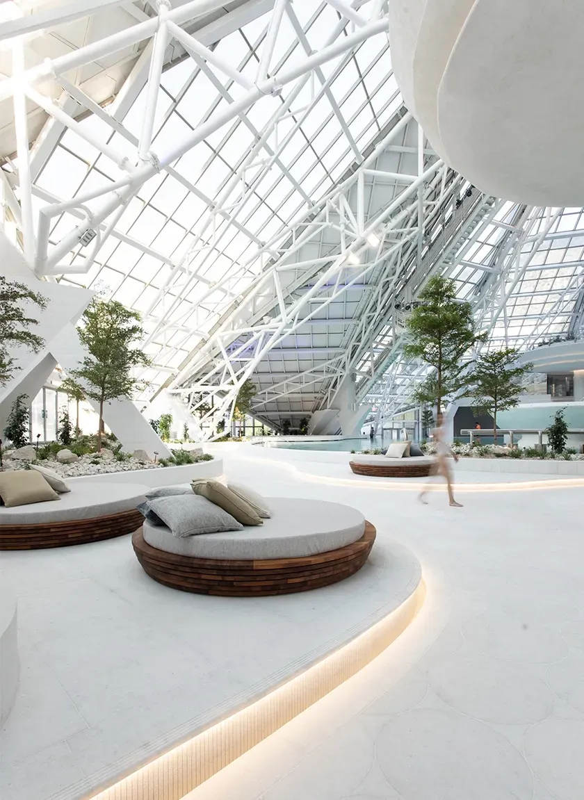 Exterior shot of a mountain spa resort with sharp architectural lines and mist rising from thermal pools.