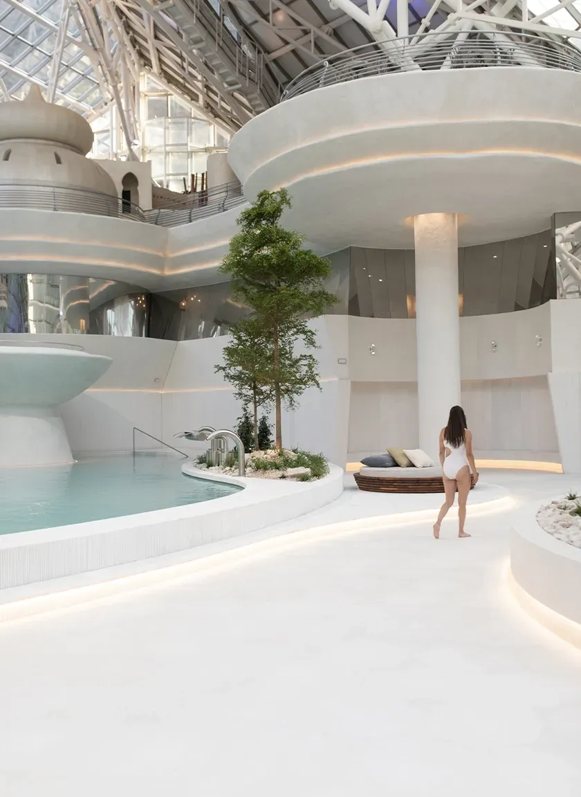 Modern wellness center interior with cascading water, curved architectural walls, and serene ambiance.