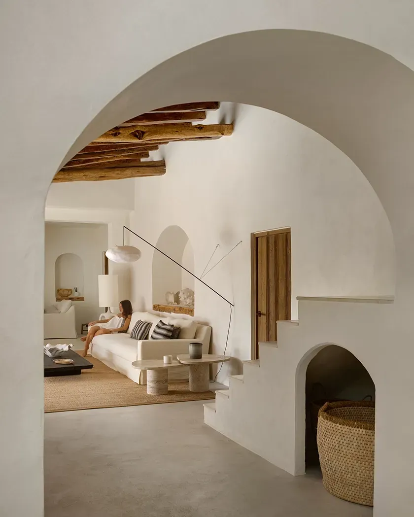 Cozy Mediterranean interior with textured walls, wooden ceiling beams, and curated decor enhancing the calm and timeless ambiance.