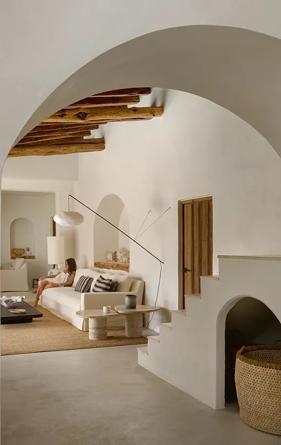 Cozy Mediterranean interior with textured walls, wooden ceiling beams, and curated decor enhancing the calm and timeless ambiance.
