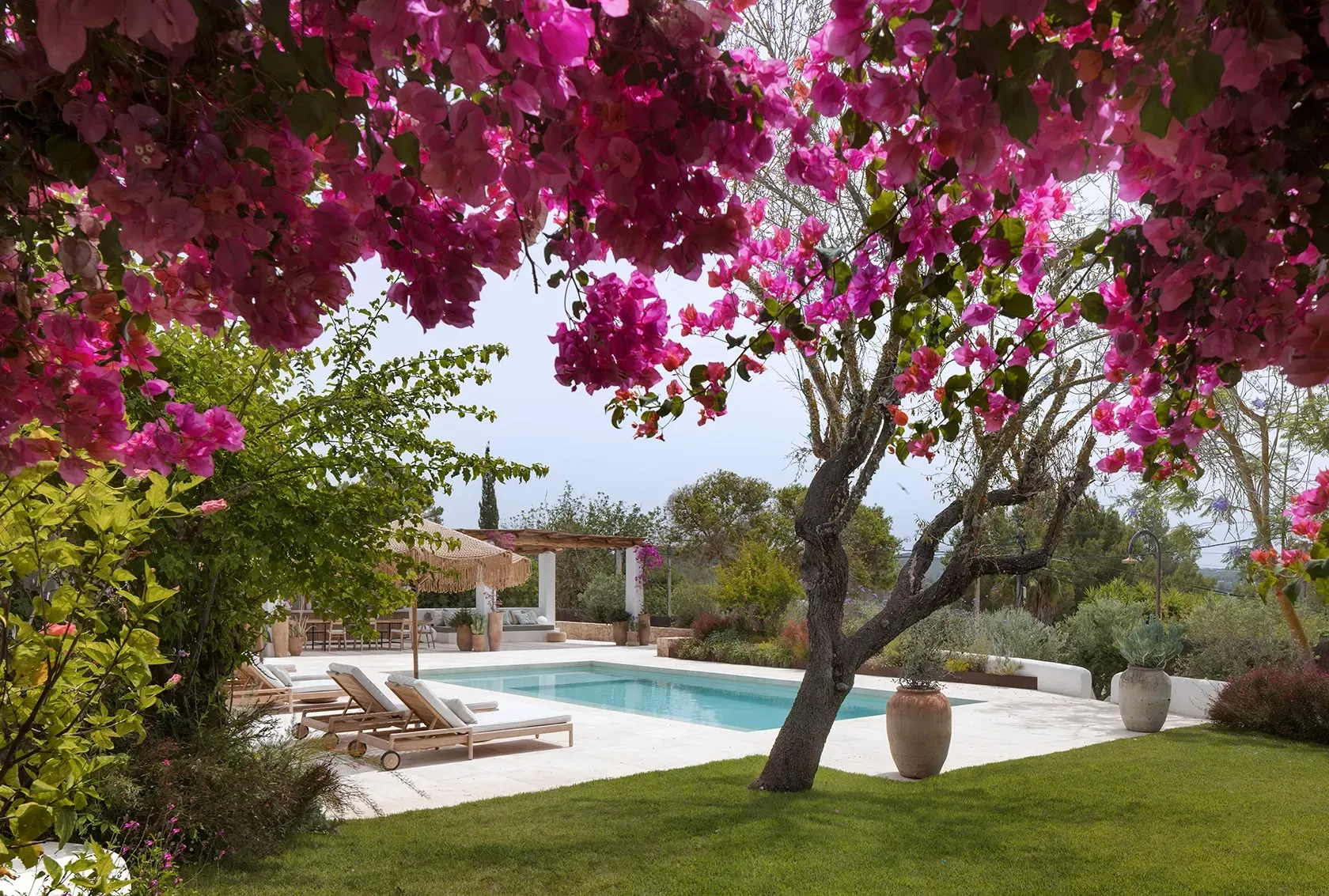 Framed by vivid bougainvillea, the elegant pool terrace blends luxury with nature, creating a vibrant, serene Mediterranean retreat.