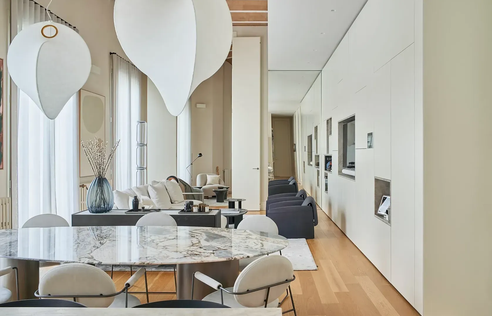 Bright dining area centered around a stylish table and chairs, accentuated by large windows and minimalist decor.