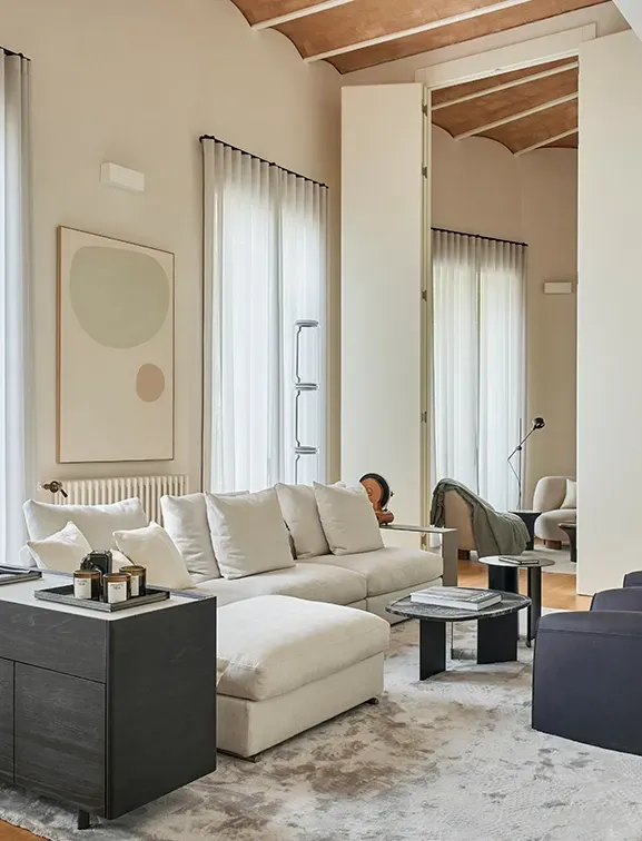 Contemporary living space with neutral tones, layered textures, and large windows that invite natural light.