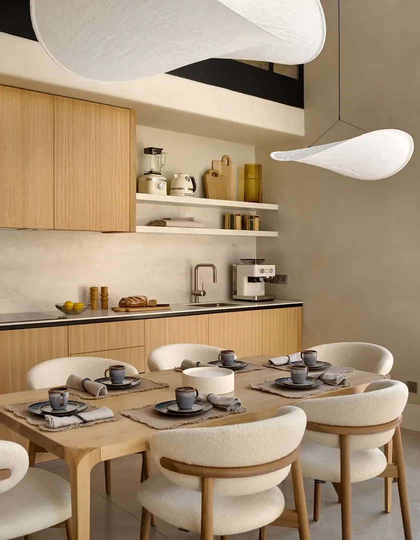 Detail of oak dining table and upholstered chairs in modern luxury interior