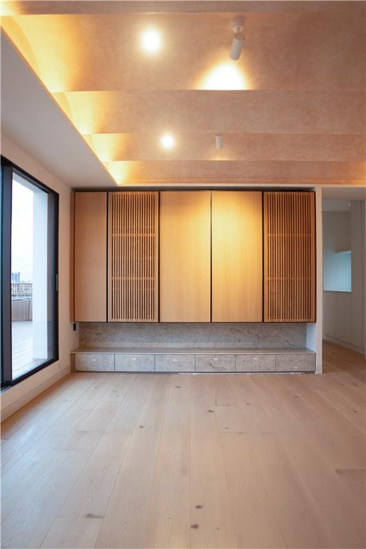 Custom living room cabinetry combining oak panels and textured surfaces in a Barcelona apartment interior