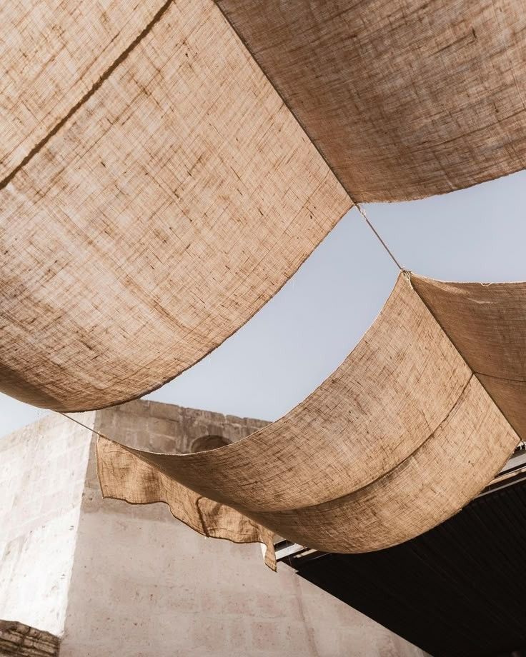 Suspended fabric textures creating shade and climatic comfort