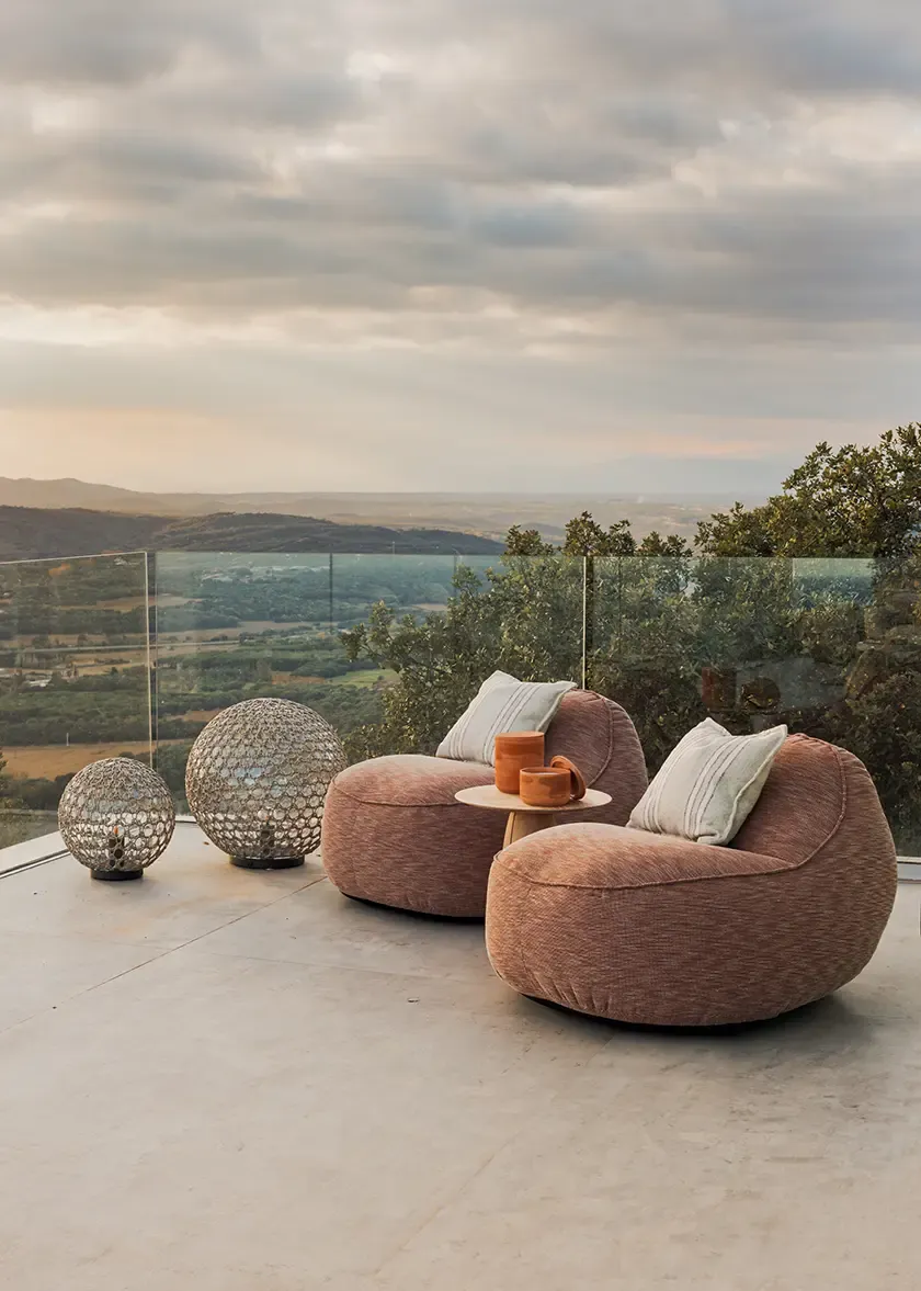 Cozy outdoor terrace with plush seating and stunning panoramic views of the landscape. The space is designed for relaxation, featuring soft cushions and stylish lighting, ideal for evening gatherings.