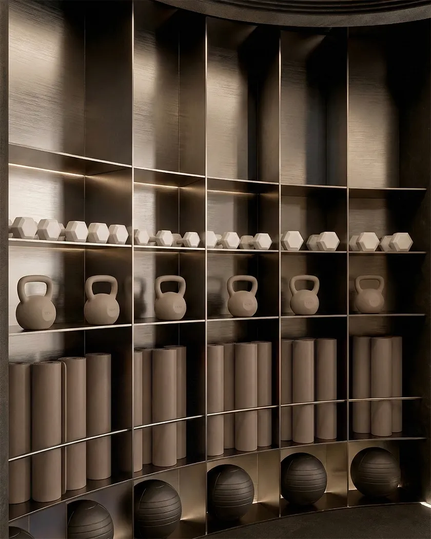 Wellness gym storage wall with integrated shelves, soft lighting and neutral training equipment