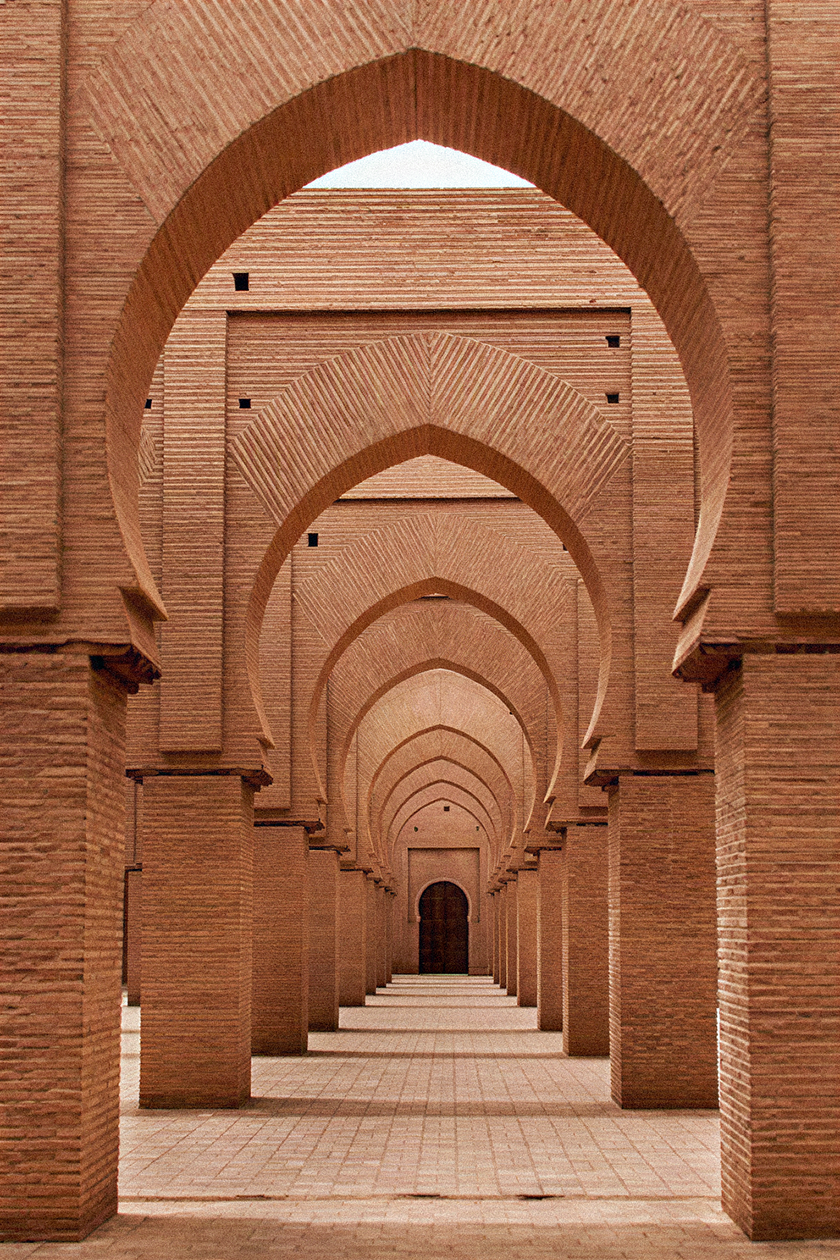 Rhythmic sequence of brick arches and colonnades showcasing geometric symmetry and traditional North African architectural design.