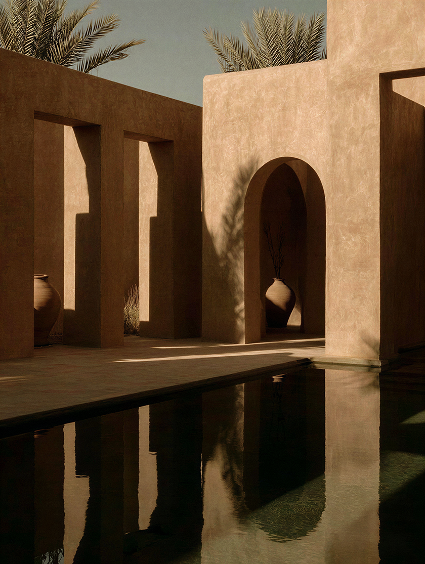 Luxury courtyard with textured earth-toned walls, arched openings, clay vessels and a reflective pool, inspired by contemporary desert architecture.