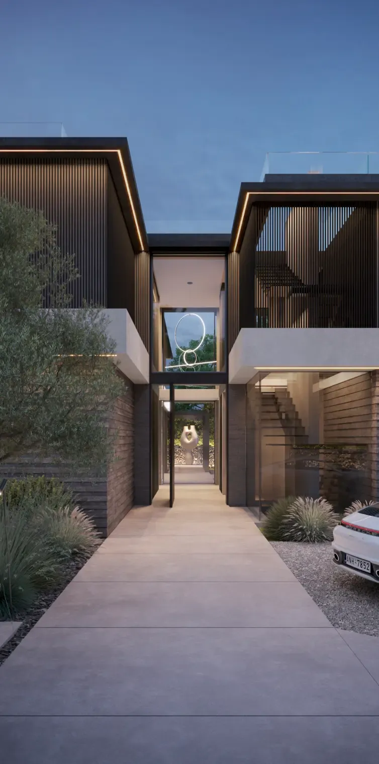 Modern luxury villa with stone façade and lush Mediterranean landscaping at the main entrance.