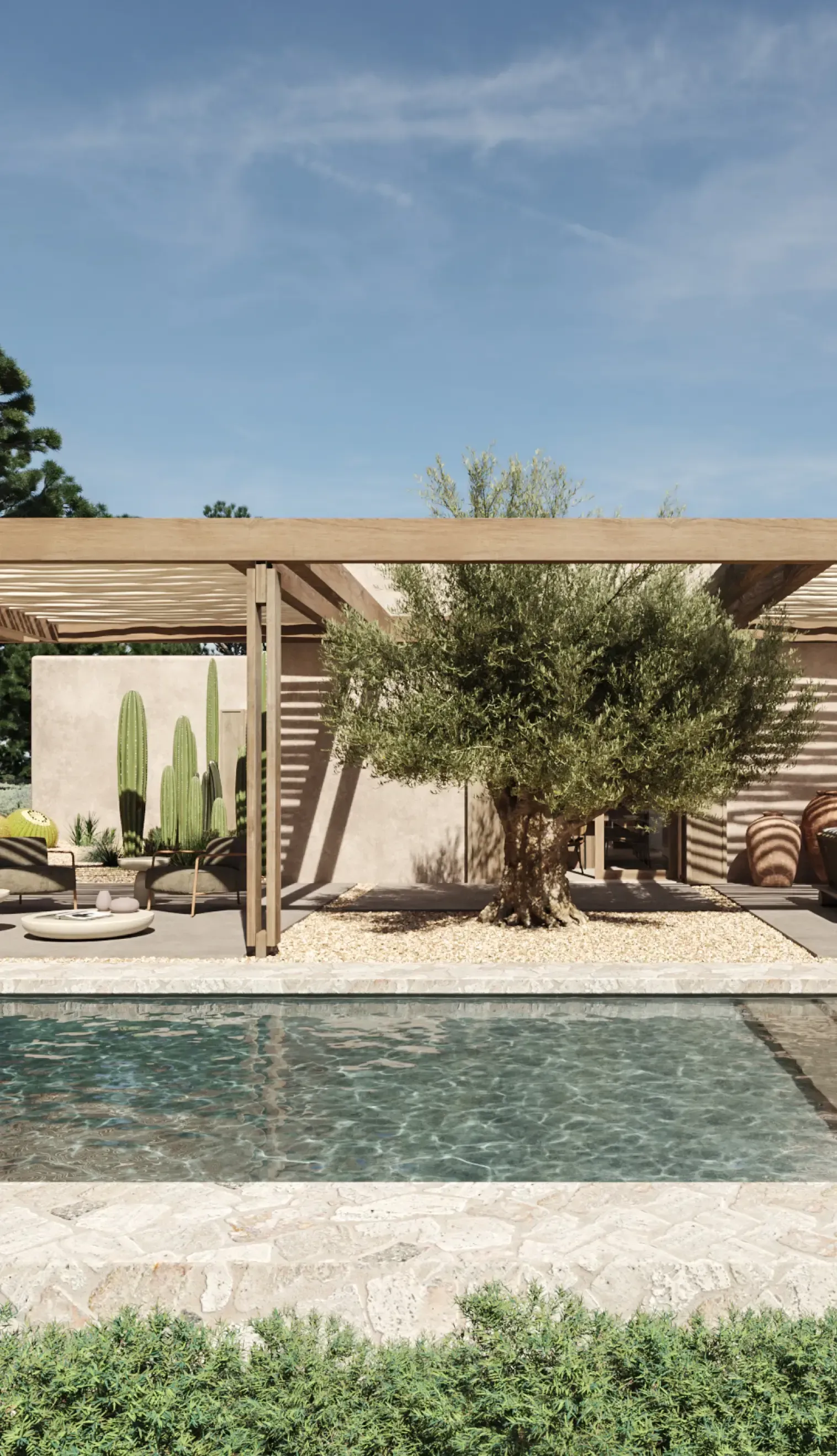 Chic villa poolside with olive tree, desert-style landscaping, and shaded outdoor sofas in Formentera.