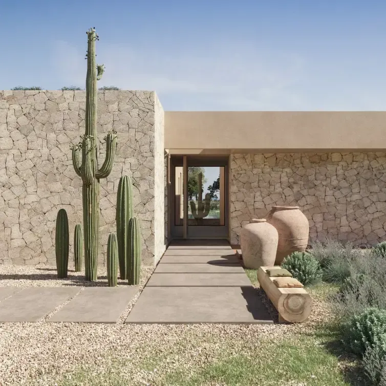 Exterior close-up of a luxury villa in Formentera, featuring cactus landscaping and stone-clad walls.