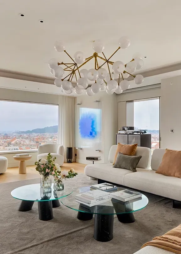 Elegant living room with panoramic city views, designer furniture, and contemporary chandelier, styled by LUV Studio for a luxury residence.