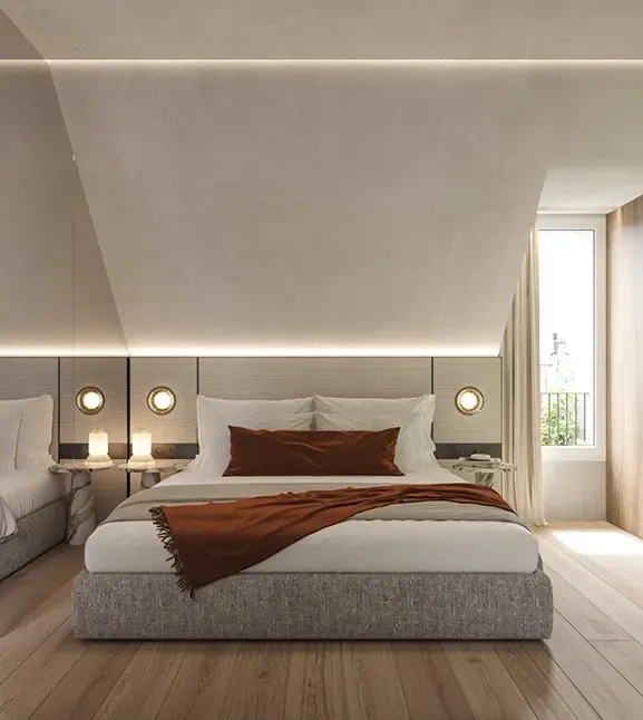 Refined bedroom suite with sloped ceilings, warm wood accents, and a cozy fireplace framed in green marble.