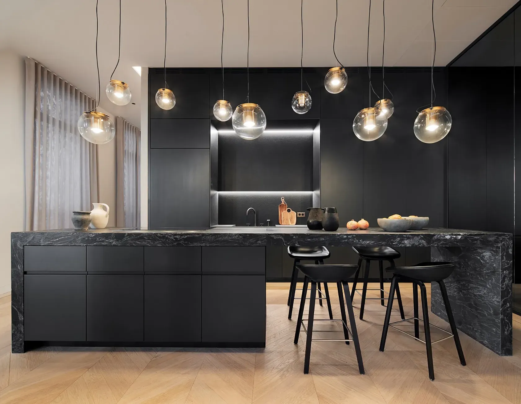 Contemporary black marble kitchen with elegant lighting, highlighting refined luxury.